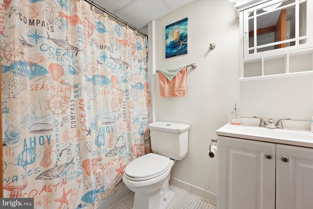 bathroom with tile patterned flooring, a drop ceiling, a shower with curtain, vanity, and toilet