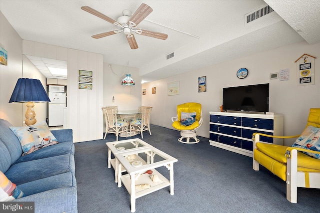 carpeted living room with a textured ceiling and ceiling fan