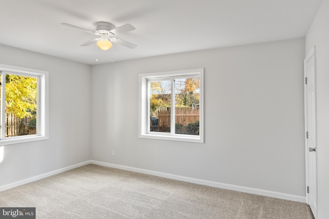 carpeted spare room featuring ceiling fan