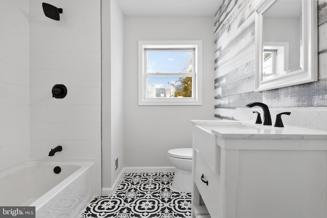 full bathroom featuring toilet, vanity, tiled shower / bath, and tile patterned flooring