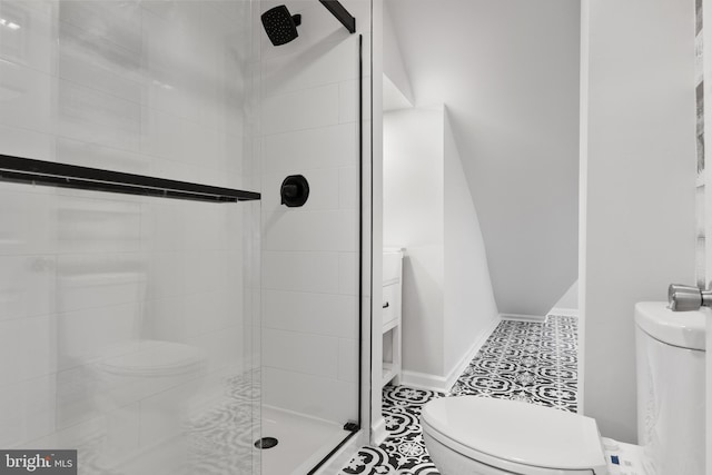 bathroom featuring tile patterned floors, toilet, and a tile shower