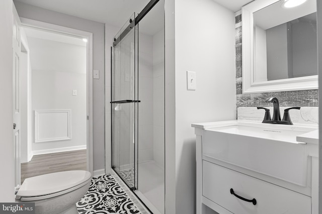 bathroom with walk in shower, hardwood / wood-style floors, vanity, and toilet