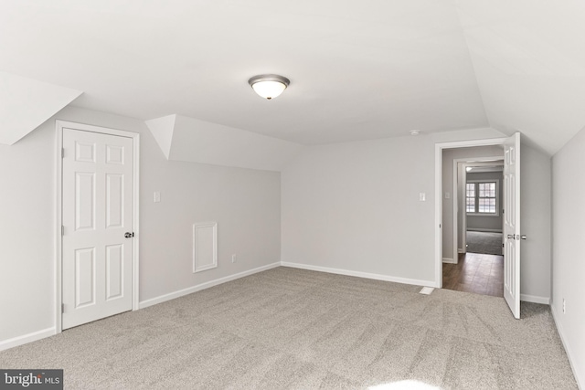 additional living space featuring carpet flooring and lofted ceiling