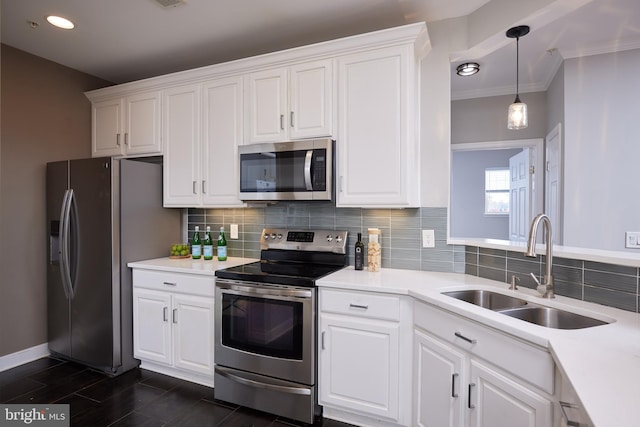 kitchen with white cabinetry, stainless steel appliances, sink, and crown molding