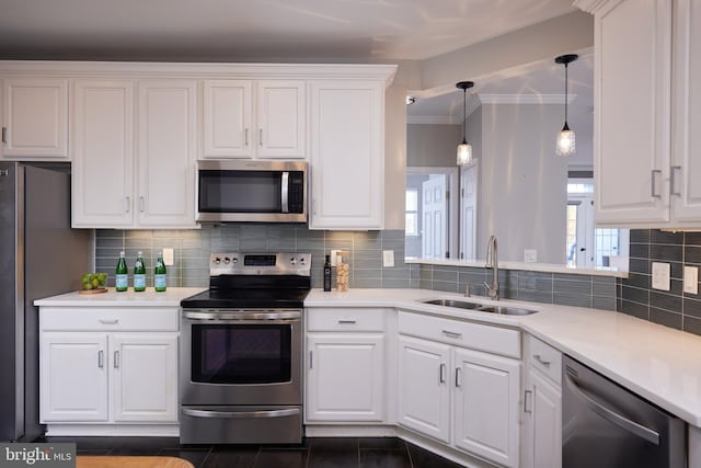 kitchen featuring stainless steel appliances, white cabinetry, sink, and pendant lighting