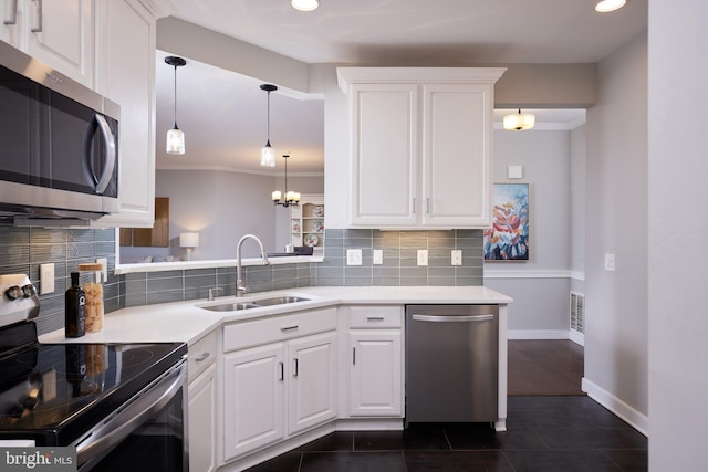 kitchen featuring sink, appliances with stainless steel finishes, ornamental molding, hanging light fixtures, and white cabinets