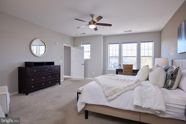 bedroom with multiple windows, light carpet, and ceiling fan