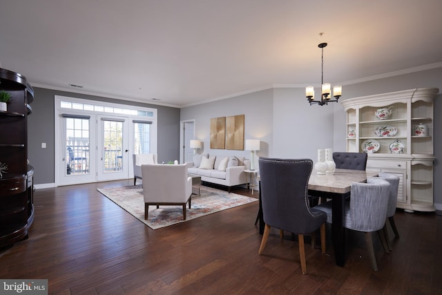 dining area with dark hardwood / wood-style flooring, an inviting chandelier, and crown molding