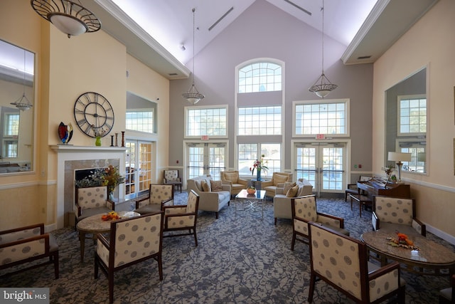 carpeted living room with high vaulted ceiling and french doors