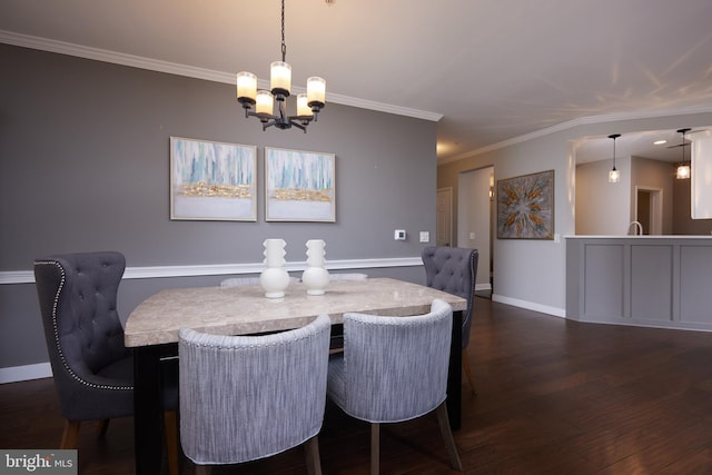 dining area featuring dark wood-type flooring, a notable chandelier, and ornamental molding