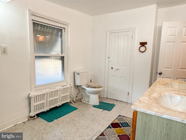 bathroom with toilet, vanity, radiator heating unit, and tile patterned floors