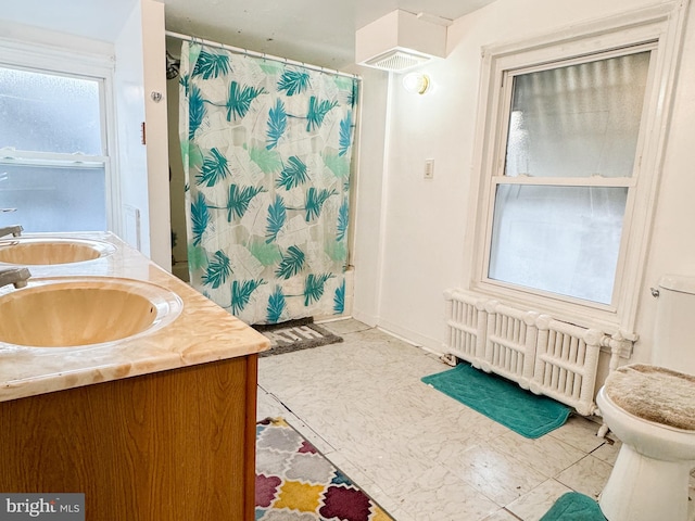 bathroom featuring tile patterned floors, vanity, radiator heating unit, and toilet