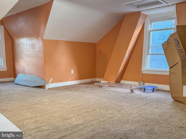 bonus room with vaulted ceiling and carpet floors