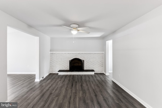 unfurnished living room with a ceiling fan, dark wood-style floors, baseboards, and a fireplace