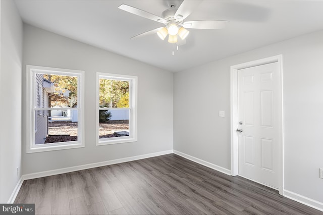 empty room with dark wood-type flooring, ceiling fan, vaulted ceiling, and baseboards