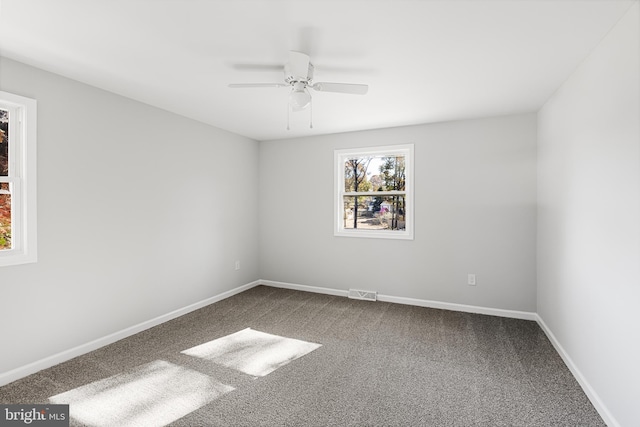 empty room featuring carpet floors, a ceiling fan, and baseboards