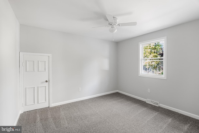 carpeted empty room with ceiling fan and baseboards