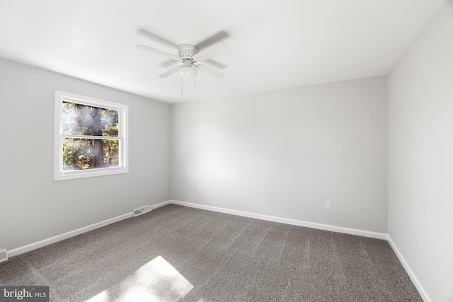 carpeted spare room with ceiling fan and baseboards