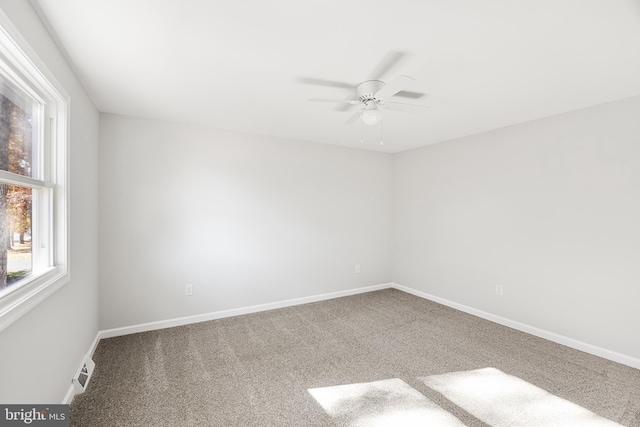 empty room featuring carpet floors, a ceiling fan, and baseboards