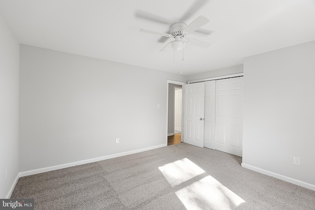 unfurnished bedroom with carpet flooring, baseboards, a closet, and ceiling fan