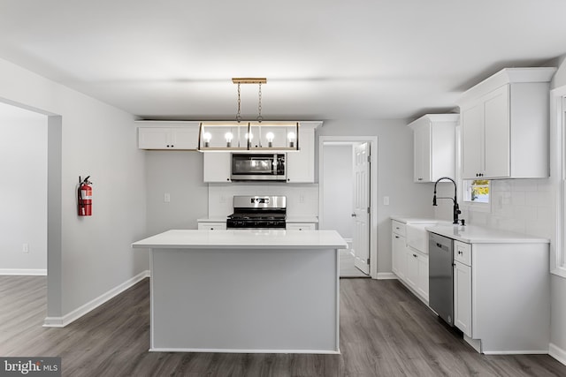 kitchen featuring appliances with stainless steel finishes, a sink, tasteful backsplash, and dark wood-type flooring