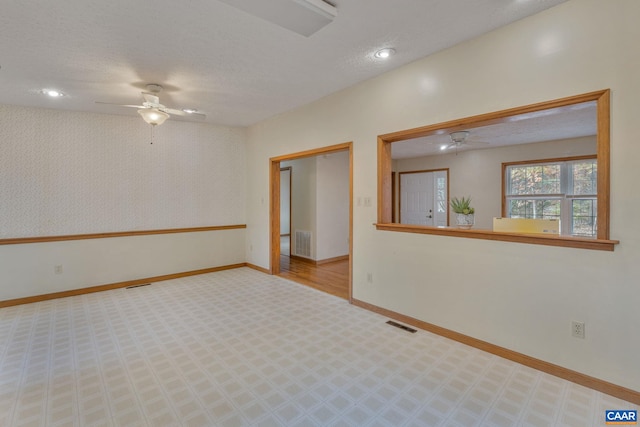 unfurnished room featuring ceiling fan and a textured ceiling