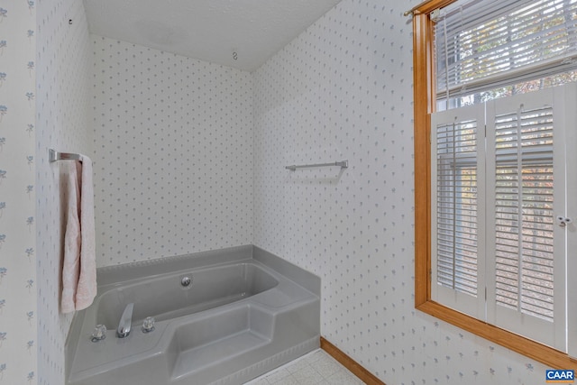 bathroom with tile patterned flooring, a bath, and a textured ceiling