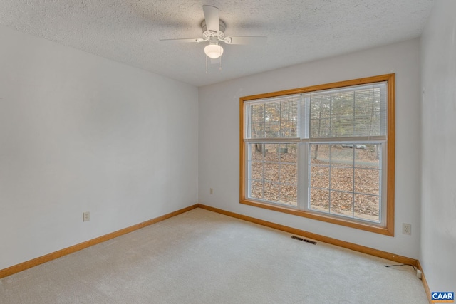 carpeted empty room featuring a textured ceiling and ceiling fan