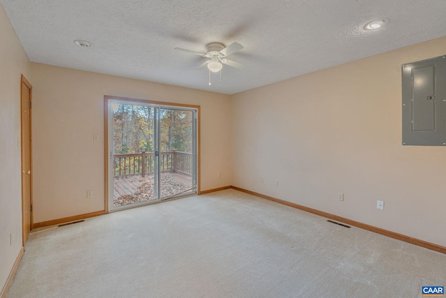 carpeted spare room featuring electric panel, a textured ceiling, and ceiling fan