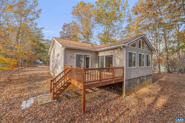 back of property with a sunroom and a deck