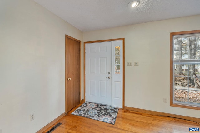 entryway featuring light hardwood / wood-style floors and a textured ceiling