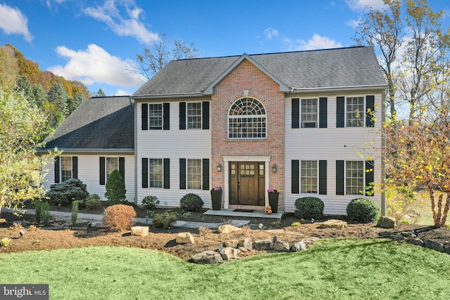 colonial house featuring a front lawn