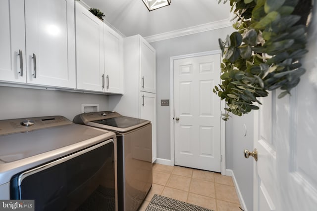 laundry room with washer and clothes dryer, cabinets, light tile patterned floors, and crown molding