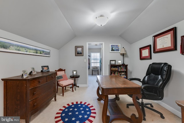 home office featuring vaulted ceiling and light colored carpet