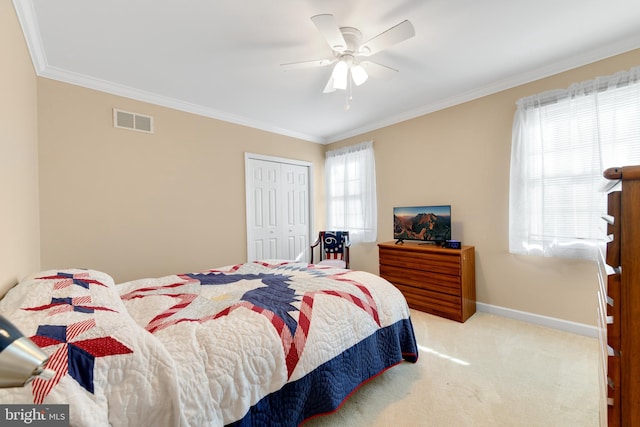 carpeted bedroom featuring ornamental molding, multiple windows, ceiling fan, and a closet