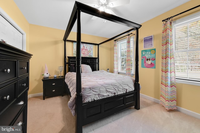 carpeted bedroom with ceiling fan and multiple windows