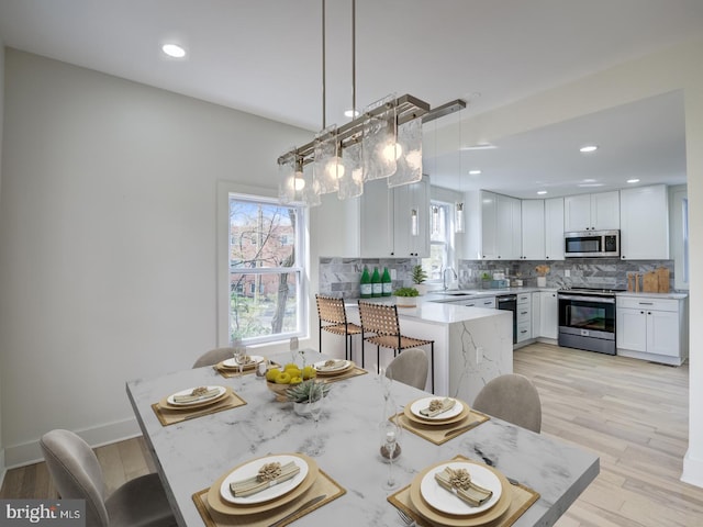 dining area with light hardwood / wood-style flooring and sink