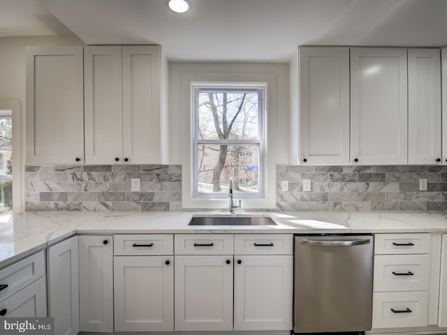 kitchen with dishwasher, white cabinetry, and sink