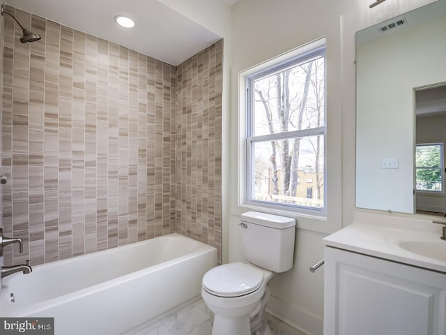 full bathroom featuring a wealth of natural light, vanity, toilet, and tiled shower / bath