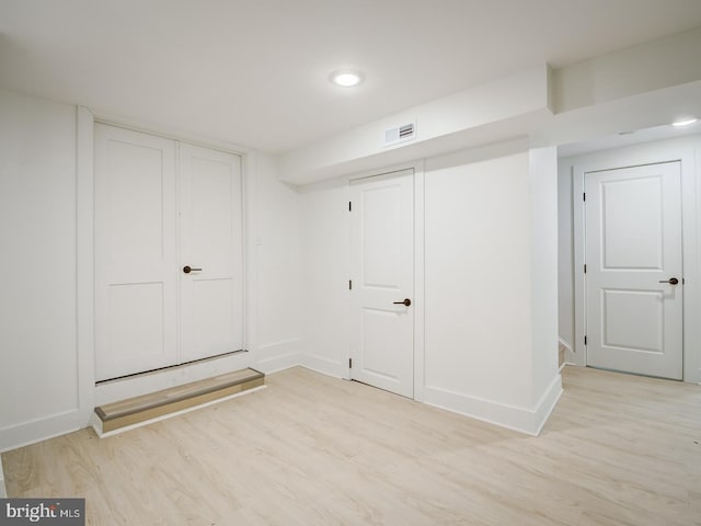 basement with light hardwood / wood-style floors