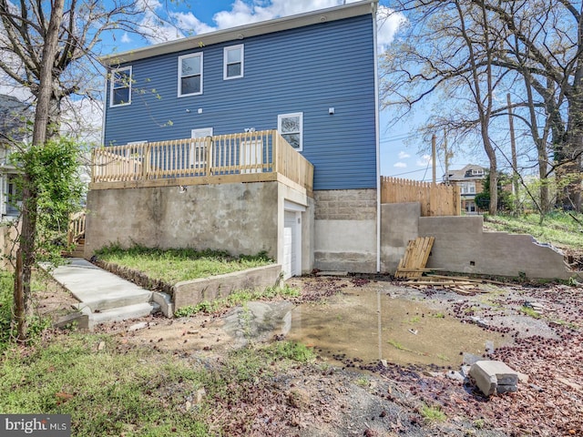 rear view of property with a garage and a deck