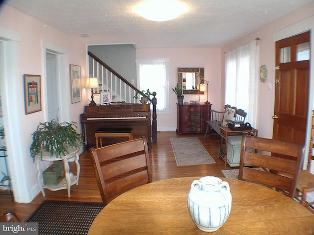 dining room featuring dark hardwood / wood-style flooring, a wealth of natural light, and a textured ceiling