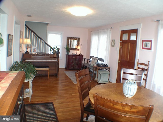 dining area featuring dark hardwood / wood-style flooring and a textured ceiling