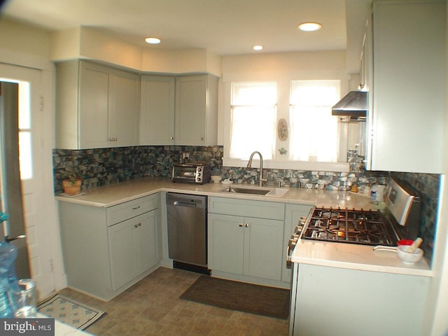 kitchen with decorative backsplash, stainless steel appliances, wall chimney exhaust hood, and sink