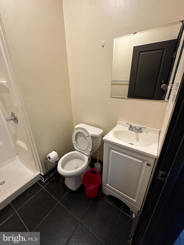 bathroom with vanity, tile patterned flooring, toilet, and a shower