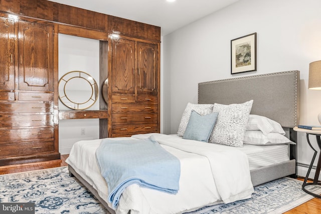 bedroom featuring hardwood / wood-style floors and a baseboard radiator