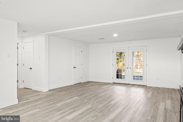 spare room featuring light wood-type flooring and french doors