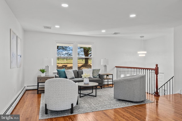 living room featuring baseboard heating and light wood-type flooring