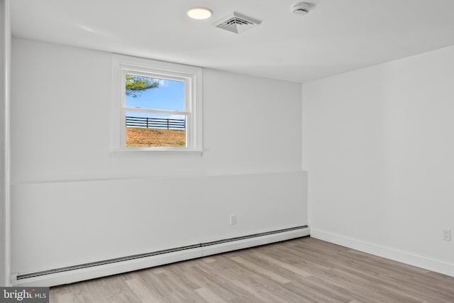 unfurnished room featuring light wood-type flooring and baseboard heating