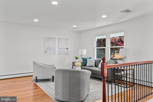 living room with a baseboard radiator and wood-type flooring